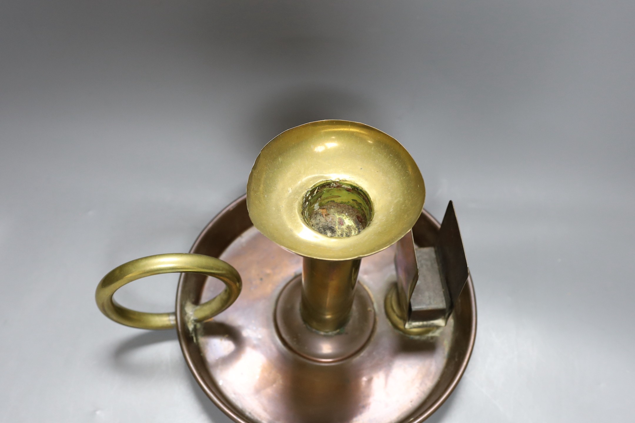 A large brass and copper chamberstick by G Farris, London, 20cm